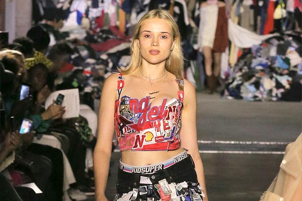 A female model walking down a runway wearing an upcycled top.